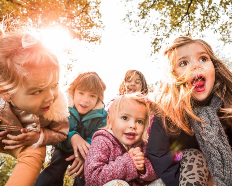 Kinderfigürchen aus verschiedenen Länder vor Globus
